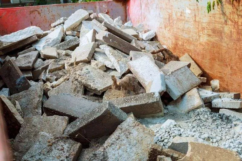 Concrete and brick rubble in a skip bin